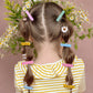 double pony tail hair style with daisies. Pony tails are sectioned with hair barrettes clipped throughout. adorable and colorful hair style.