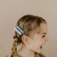 girl hairdo, blue scallop hair clip, light blue floral clip on a braid