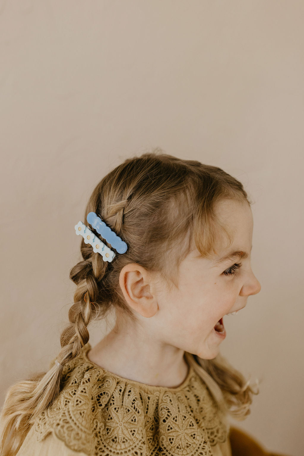 girl hairdo, blue scallop hair clip, light blue floral clip on a braid